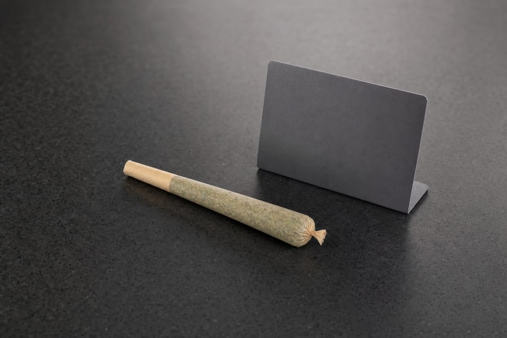 Small cannabis pre-roll cone on a dark countertop with a price tag at a Weed shop near downtown Brockton